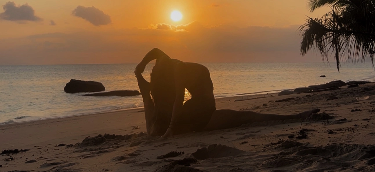 grand ecart au coucher du soleil sur plage